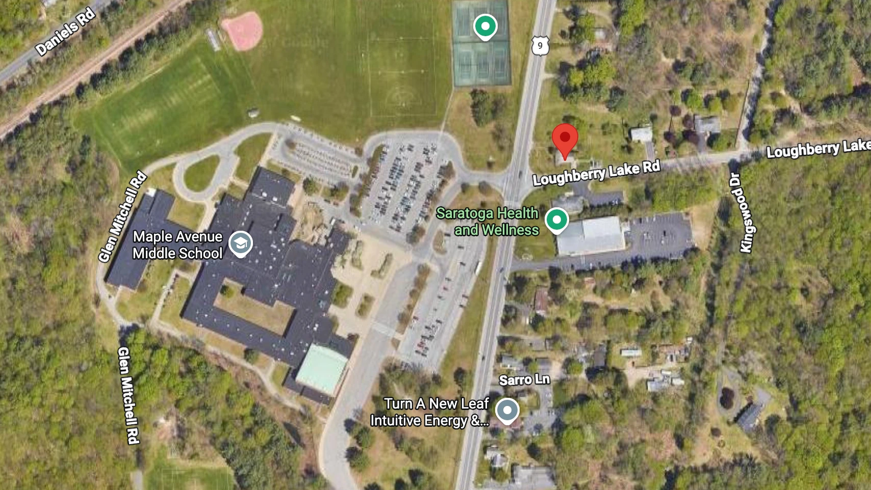 Aerial view of Maple Ave (Route 9) and Loughberry Lake Road in Wilton, NY. A red pin marks the proposed car wash site at the northeast corner of the intersection, directly across Route 9 from Maple Avenue Middle School.